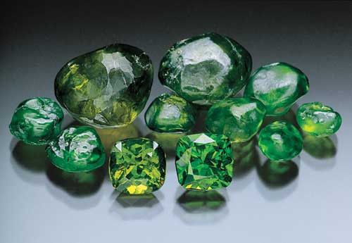 Rough and cut demantoid garnets